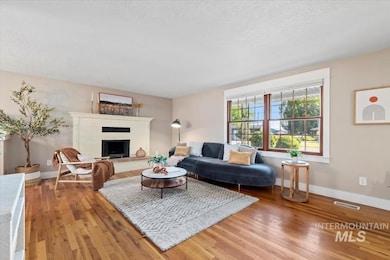 Living room with wood finished floors, a fireplace, and a textured ceiling