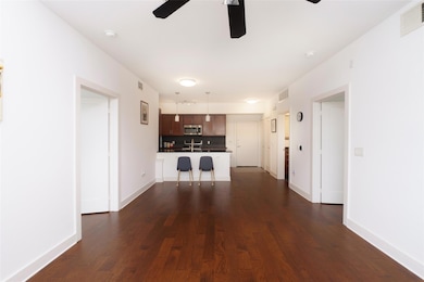 Unfurnished living room with ceiling fan, dark wo