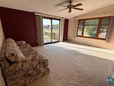 Bedroom with access to exterior, carpet floors, vaulted ceiling, and ceiling fan