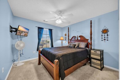 Bedroom with carpet, visible vents, ceiling fan, a