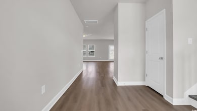 Hallway featuring wood finished floors and baseboards