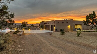 Pueblo-style home with driveway, an attached garage, and stucco siding