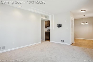 Spare room with light carpet, recessed lighting, and a chandelier