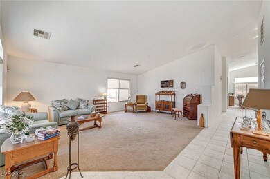 Living area featuring vaulted ceiling, light tile