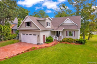 View of front of property featuring roof with shingles, a front yard, and decorative driveway