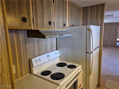 Kitchen featuring under cabinet range hood, white