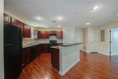 Kitchen featuring visible vents, dark wood-style f