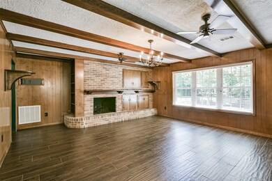 Enter the picturesque den with fireplace with warm wood tones and built in storage.