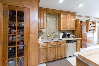 The kitchen has patterned tile work above the kitc