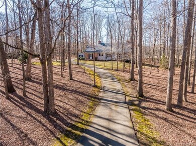 A long, tree-lined driveway offers privacy and gre