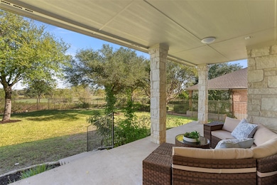 The covered patio space is expansive and provides a peaceful space for relaxation along with a lovely greenbelt view.