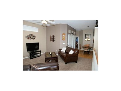 Living room with newer carpets and ceiling fan.