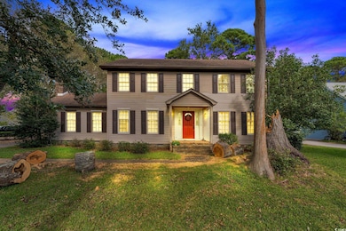 Colonial-style house with a lawn