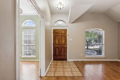 Entryway featuring vaulted ceiling, wood-type floo