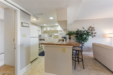 Kitchen featuring a breakfast bar area, white appl
