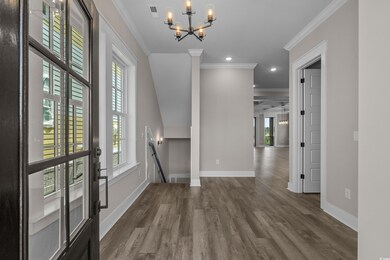 Foyer entrance featuring wood finished floors, ornamental molding, a chandelier, and recessed lighting