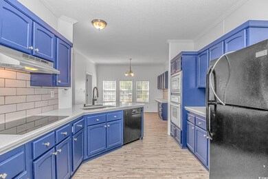 Kitchen with black appliances, a sink, under cabinet range hood, a peninsula, and light wood finished floors