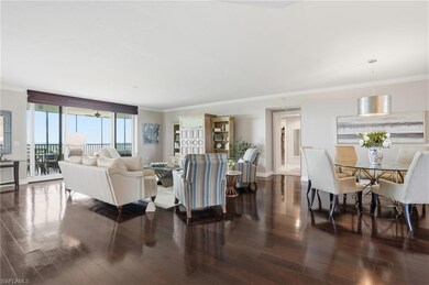 Living room featuring crown molding and dark wood-style flooring