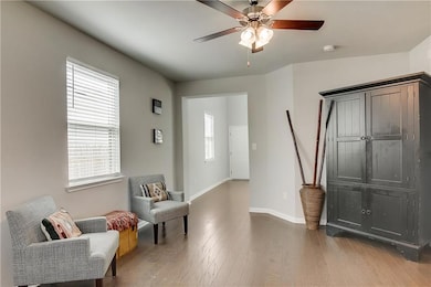 Living area with ceiling fan and wood finished fl