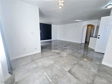 Empty room featuring arched walkways and baseboard