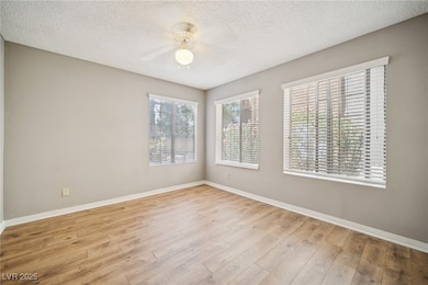 Empty room featuring baseboards, a ceiling fan, wo