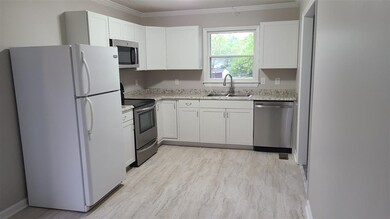 Kitchen with lots of light. Window looks out into the front yard. Living room to the right. (refrigerator stays)