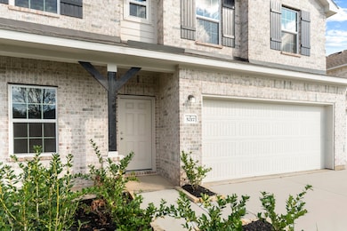 A closer look at the front entry reveals a warm and welcoming design! The covered porch provides the perfect spot for a friendly greeting or seasonal décor. The 3-car garage features a clean, modern door design and smooth driveway access—ideal for extra parking or storage needs.