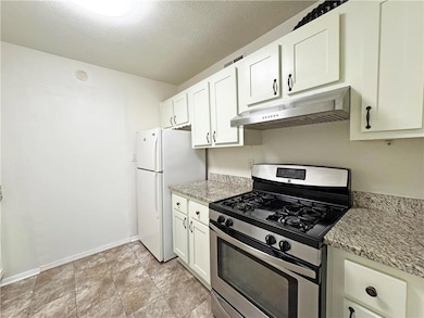 Kitchen featuring white cabinets, stainless steel 