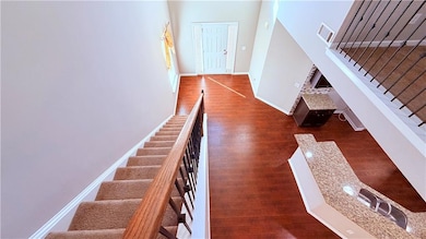 Stairs with wood finished floors and baseboards