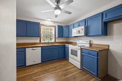 Kitchen featuring wood counters, white appliances,