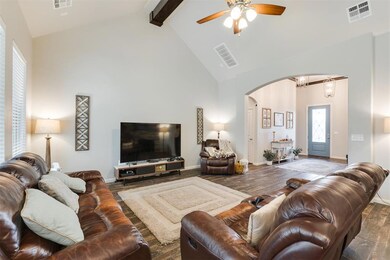 Living room featuring a ceiling fan, beamed ceilin