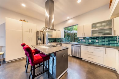 Kitchen with a sink, backsplash, concrete floors,