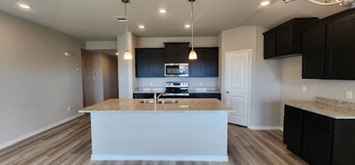 Kitchen featuring light stone countertops, sink, s
