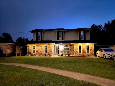 house with a front lawn and brick siding