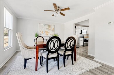Dining room featuring crown molding, light hardwoo