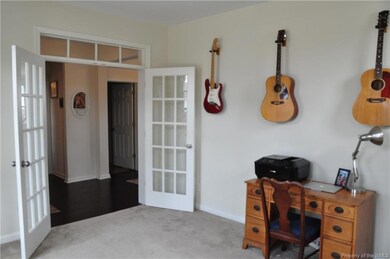 French doors open to a den or study or office area.