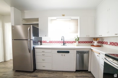 Kitchen with white cabinets, stainless steel appliances, and light countertops