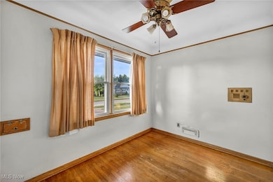 Unfurnished room featuring wood-type flooring, crown molding, and ceiling fan