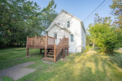 Back of property with a yard and a wooden deck