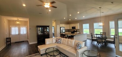 Living room with ceiling fan with notable chandeli