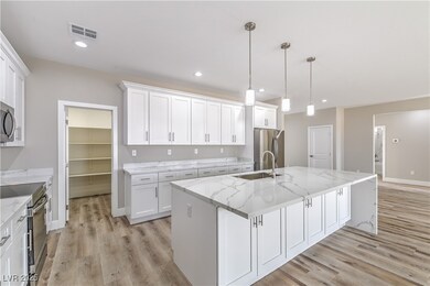 Kitchen with a sink, an island with sink, visible