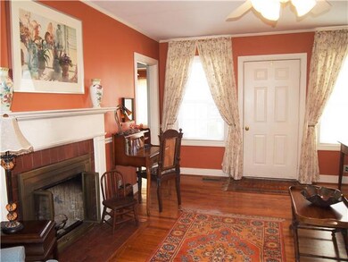 Cheery Living Room with beautiful hardwood floors, nice chair rail, and great lighting from the two front windows and glass backdoor
