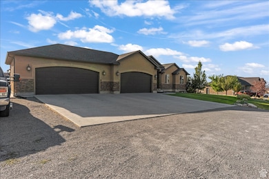 Ranch-style home featuring driveway, a garage, and stucco siding