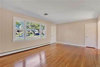Large Living Room with fresh neutral paint, large picture window, and beautiful hardwoods