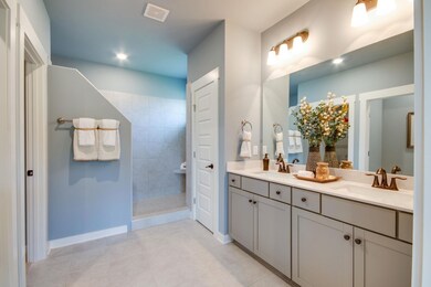 Master bathroom has tiled flooring, tall double bowl vanities, quartz countertops and Moen faucets