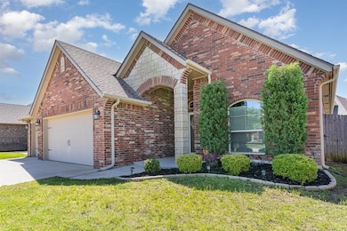 View of front of home featuring a garage, brick siding, concrete driveway, and a shingled roof
