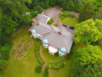 Aerial view showcasing gorgeous landscaping and rear facade of home