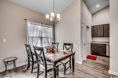 Dining space with high vaulted ceiling, a chandeli