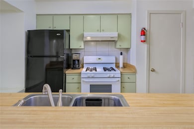 Kitchen featuring green cabinets, white gas stove
