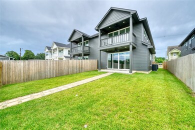 Rear view of house with a balcony, a fenced backya